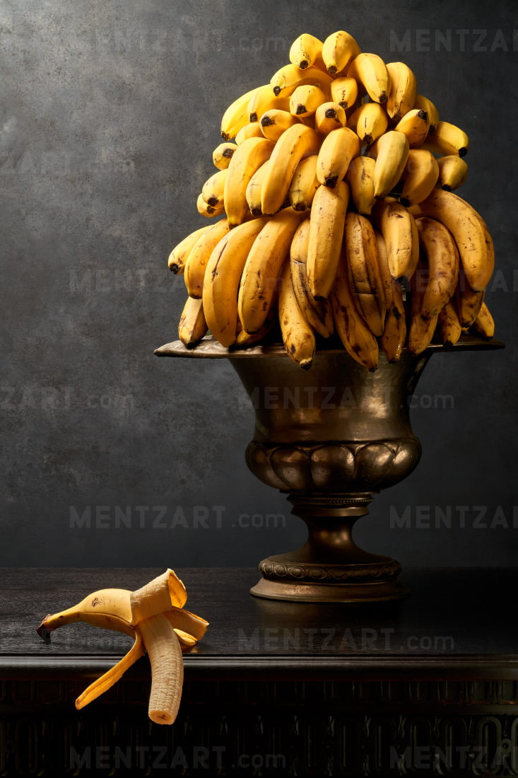 Still life with a big bunch of bananas in a silver bowl